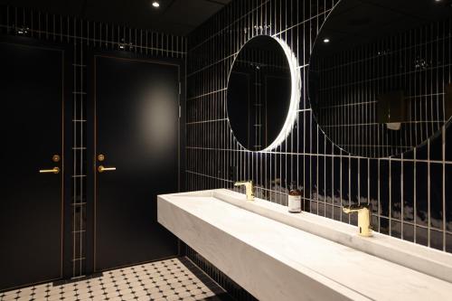 Baño con 2 lavabos y espejo en Quality Hotel Florø, en Florø