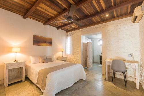 a bedroom with a bed and a table and a chair at Quaint 4-bedroom Beach Villa in a fishing village in Grand Gaube