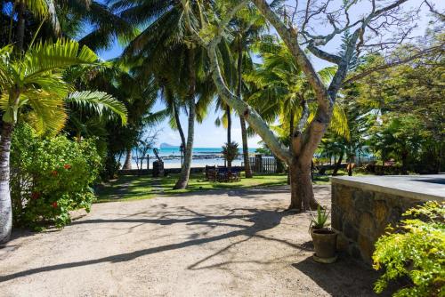 a park with palm trees and the ocean in the background at Quaint 4-bedroom Beach Villa in a fishing village in Grand Gaube