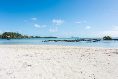 a sandy beach with a view of the ocean at Quaint 4-bedroom Beach Villa in a fishing village in Grand Gaube