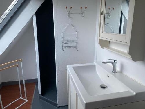 a bathroom with a white sink and a staircase at Longère Bretonne près du GR34 in Trébeurden