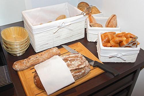 Una mesa con pan y pasteles y cestas de pan. en Haus Anna an der Stadtmauer, en Hanau am Main