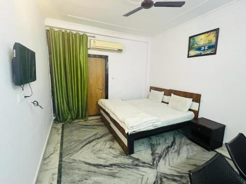 a bedroom with a bed and a green curtain at Hotel Apollo - Near Apollo Hospital in New Delhi
