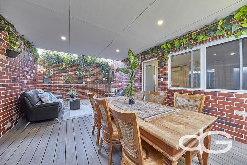 a patio with a wooden table and chairs at Federal Apartments South Fremantle in South Fremantle