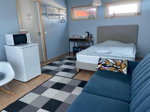 um pequeno quarto com uma cama e um sofá em Cozy Blue Apartment em Vantaa