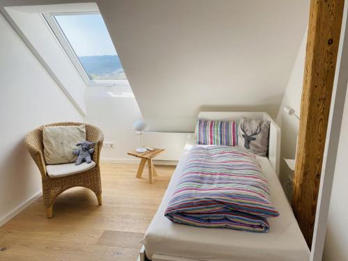 1 dormitorio con 1 cama, 1 silla y 1 ventana en Ferienwohnung Haus Alpenblick en Lenzkirch