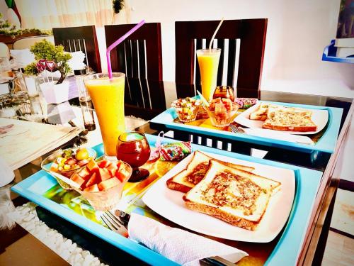 two trays of food on a table with drinks at Airport Faith Hotel in Katunayake