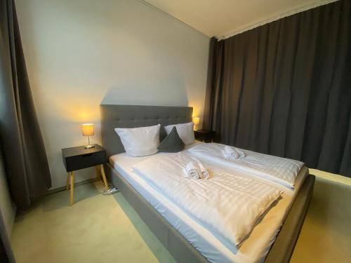 um quarto com uma cama com duas toalhas em Exklusives Penthouse 232QM Whirlpool 28min bis Düsseldorf Messe em Mönchengladbach