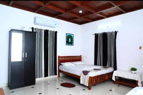 a bedroom with a large bed in a room at Mundro Garden Homestay in Munroe Island