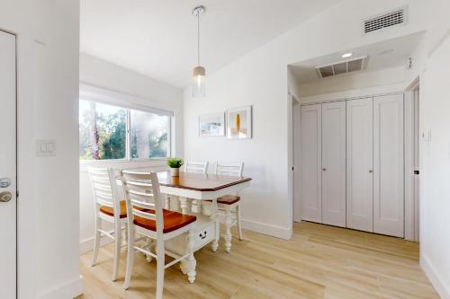 a white dining room with a table and chairs at Sparks & Sunshine in Cape Canaveral