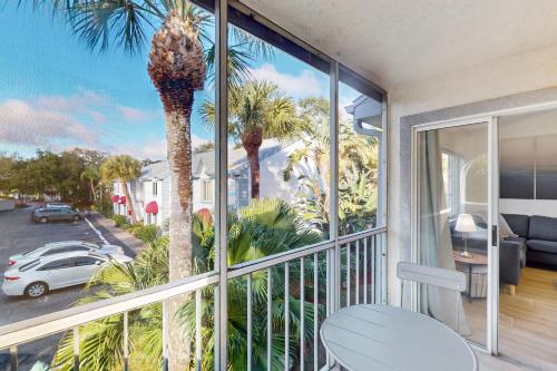 a balcony with a table and a palm tree at Sparks & Sunshine in Cape Canaveral