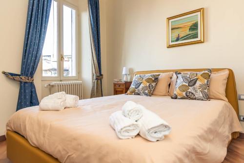 una camera da letto con un letto e asciugamani di L' Antica Piazzetta in Franciacorta a Capriolo