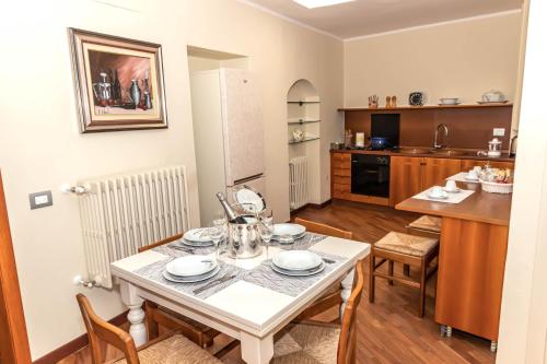 una cucina e una sala da pranzo con tavolo e sedie di L' Antica Piazzetta in Franciacorta a Capriolo
