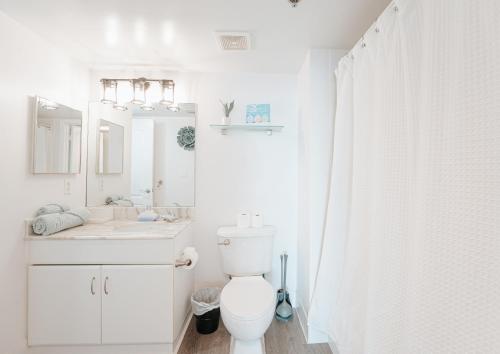 a white bathroom with a toilet and a sink at Bay Front Highrise Oasis in Brickell in Miami
