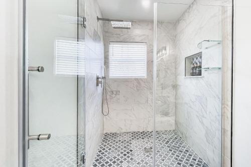 a bathroom with a shower with a glass door at Historic Culpeper Farmhouse in Culpeper