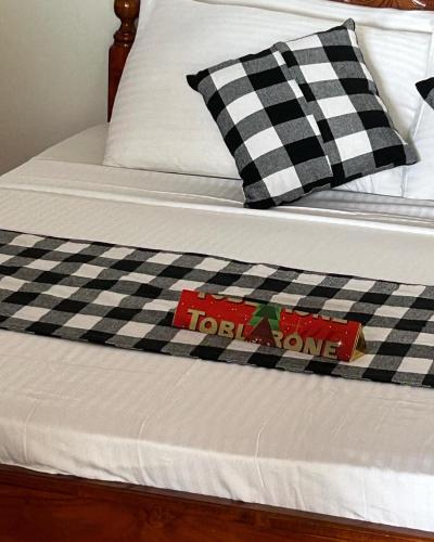a bed with a black and white checkered blanket at Kenno's Korner in Weligama