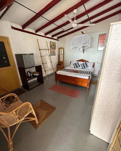 a bedroom with a bed and a television in it at Kenno's Korner in Weligama