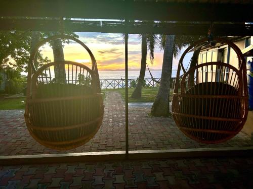 two hanging chairs with the ocean in the background at Kenno's Korner in Weligama