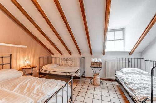 1 dormitorio con 2 camas y ventana en Valley view cottage vlakbij Valkenburg, en Voerendaal