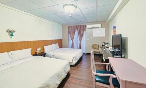 Habitación de hotel con 2 camas y escritorio en 逸仙溫泉旅宿Yi-Shian Hotsprin House, en Wenquan