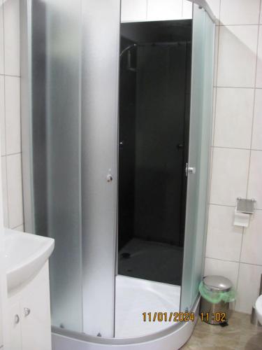 La salle de bains est pourvue d'une douche avec une porte en verre. dans l'établissement ziedu pasaule 2, à Krāslava