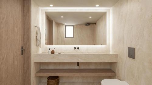 a bathroom with a sink and a mirror at Iolida Beach by Smile Hotels in Agia Marina Nea Kydonias