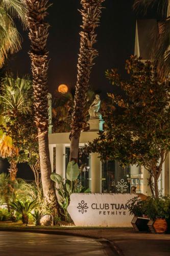 a sign in front of a building with palm trees at Club Tuana Fethiye - All Inclusive in Fethiye