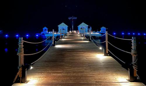 a wooden pier with lights on the water at night at Club Tuana Fethiye - All Inclusive in Fethiye