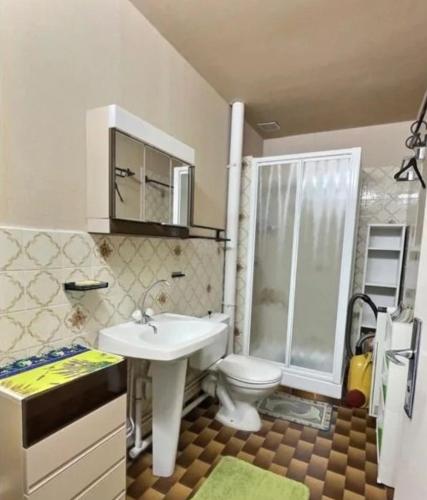 une salle de bain avec un lavabo blanc et des toilettes dans l'établissement Guti, à Valras-Plage