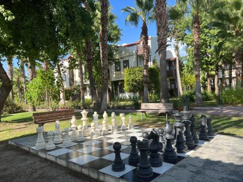 a chess board on a park with a building at Club Tuana Fethiye - All Inclusive in Fethiye