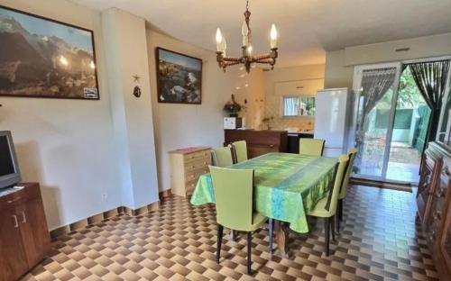 une salle à manger avec une table et des chaises vertes dans l'établissement Guti, à Valras-Plage