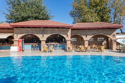 a swimming pool in front of a building at Club Tuana Fethiye - All Inclusive in Fethiye