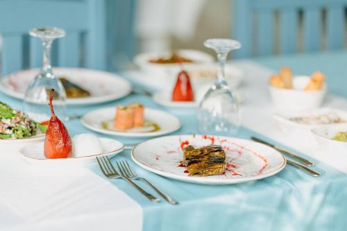 a table with plates of food and wine glasses at Club Tuana Fethiye - All Inclusive in Fethiye