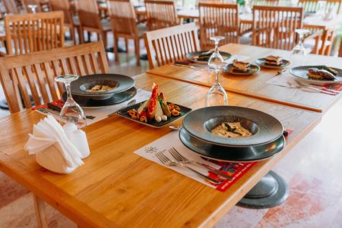 a wooden table with plates of food and wine glasses at Club Tuana Fethiye - All Inclusive in Fethiye