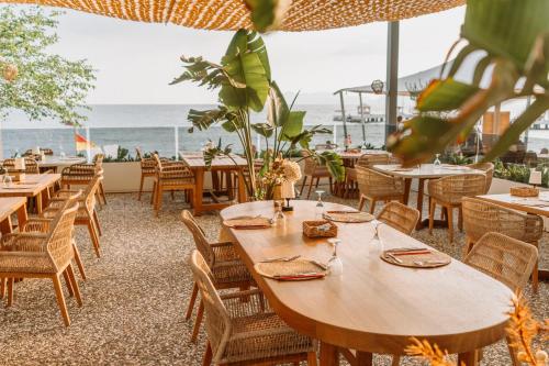 a restaurant with tables and chairs with the ocean in the background at Club Tuana Fethiye - All Inclusive in Fethiye