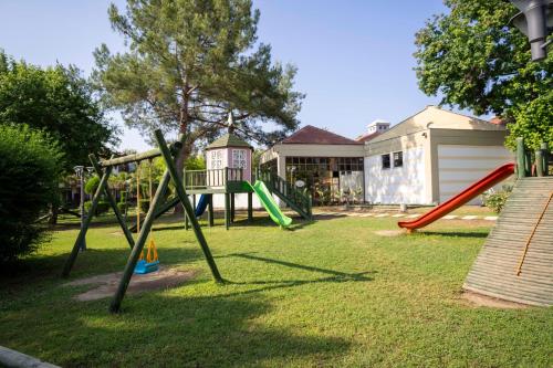 a yard with a playground with a slide at Club Tuana Fethiye - All Inclusive in Fethiye