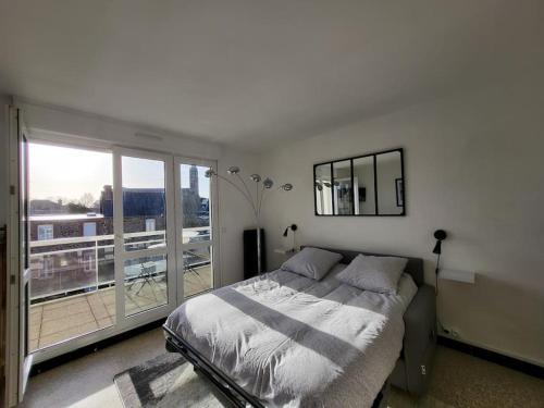 um quarto com uma cama e uma grande janela em Studio "La Parenthèse", à 50 mètres de la plage em Saint-Quay-Portrieux