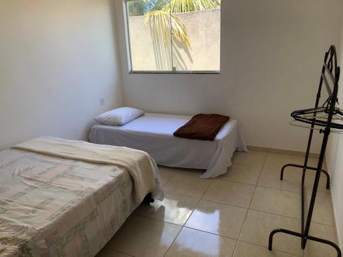 Cette chambre comprend 2 lits et une fenêtre. dans l'établissement Casa na praia d’Ulé, à Guarapari