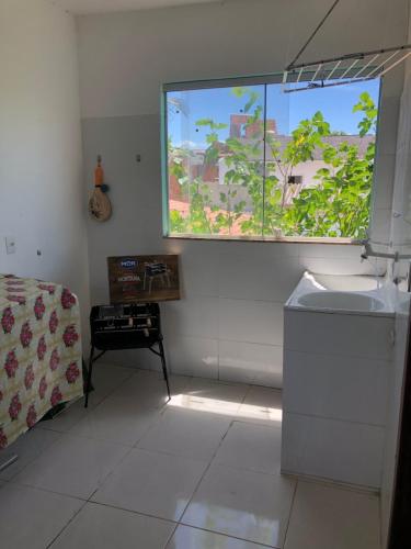 Habitación blanca con ventana y lavamanos en Casa na praia d’Ulé en Guarapari