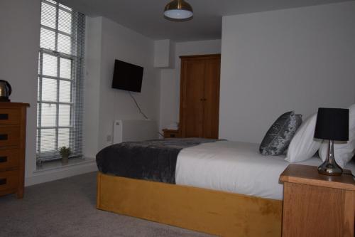 een slaapkamer met een bed en een tv aan de muur bij 9 Plants Yard in Worksop