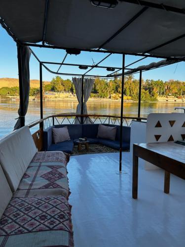 a boat with couches and a table on the water at Houseboat Hotel and Nile Cruises Zainoba in Nag` el-Ramla