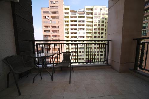 a balcony with a table and chairs and buildings at Sweet Home Apart-Hotel in Yerevan
