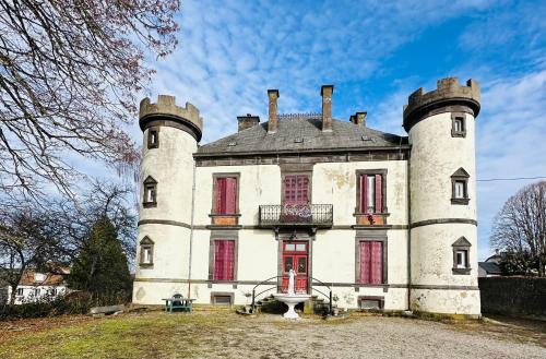 an old castle with red shutters on top of it at Le Château Giat in Giat