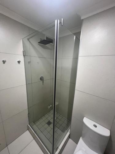 a glass shower in a bathroom with a toilet at Modern Apartment in Chapel Towers in Cape Town