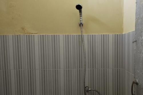 La salle de bains est pourvue d'une douche avec un pommeau de douche. dans l'établissement OYO 93657 Puri Batu Bolong, à Senggigi
