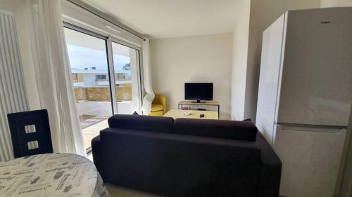 sala de estar con sofá y TV en Coeur Boisé, en Capbreton