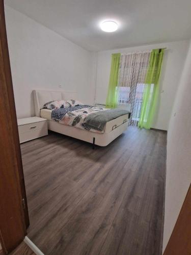 een slaapkamer met een bed en een houten vloer bij Sobe Lejla in Vipava