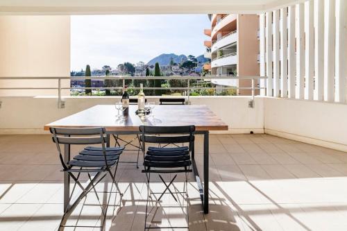 une salle à manger avec une table et quatre chaises dans l'établissement La Ciotat beau T3, mer, centre, climatisation, parking privé gratuit, à La Ciotat