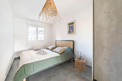 une chambre avec un lit et un lustre dans l'établissement La Ciotat beau T3, mer, centre, climatisation, parking privé gratuit, à La Ciotat