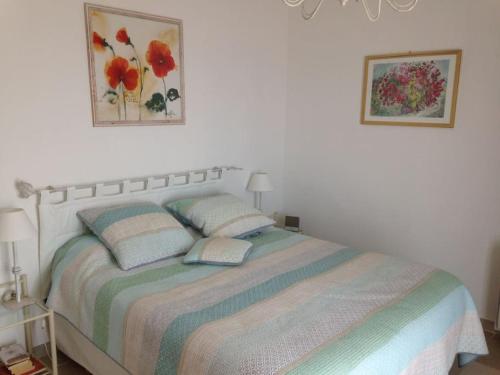 une chambre avec un lit avec deux oreillers dessus dans l'établissement Grande villa 230 m2 avec piscine et vue mer panoramique à proximité des Plages et du Circuit Paul Ricard, à Saint-Côme